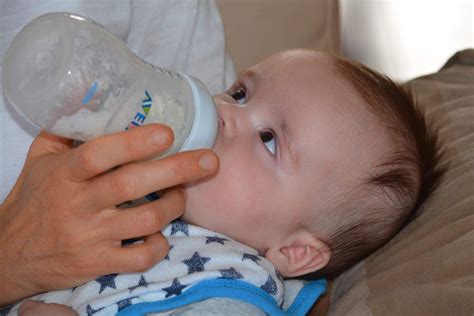 baby squirms and cries while bottle feeding|baby crying while bottle feeding.